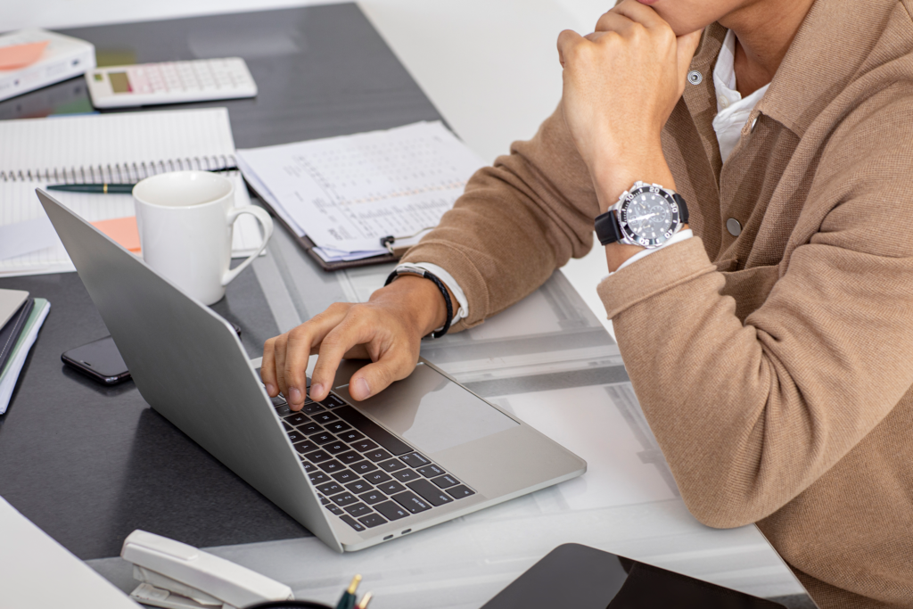 노트북으로 책상위에서 작업하는 사람